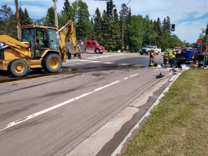 Firefighters and street crews work to clean up the fuel spill from the accident at the temporary stoplight. Submitted photo