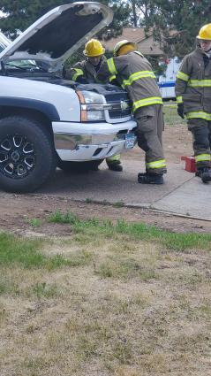 Grand Marais firefighters inspect a pickup truck engine to ensure a fire is out. Photo by Rhonda Silence