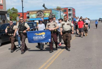 Law Enforcement officials leading the Special Olympics torch through Grand Marais in 2019 - File Photo by Rhonda Silence